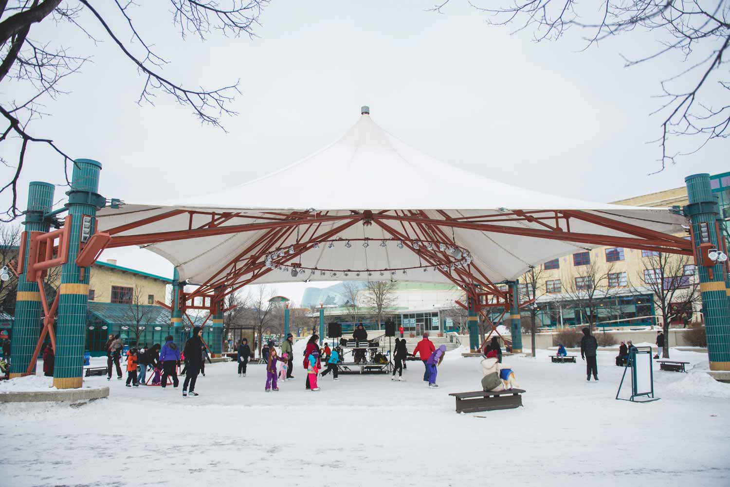 People skating under the white tent canopy of the Market Plaza in 2015