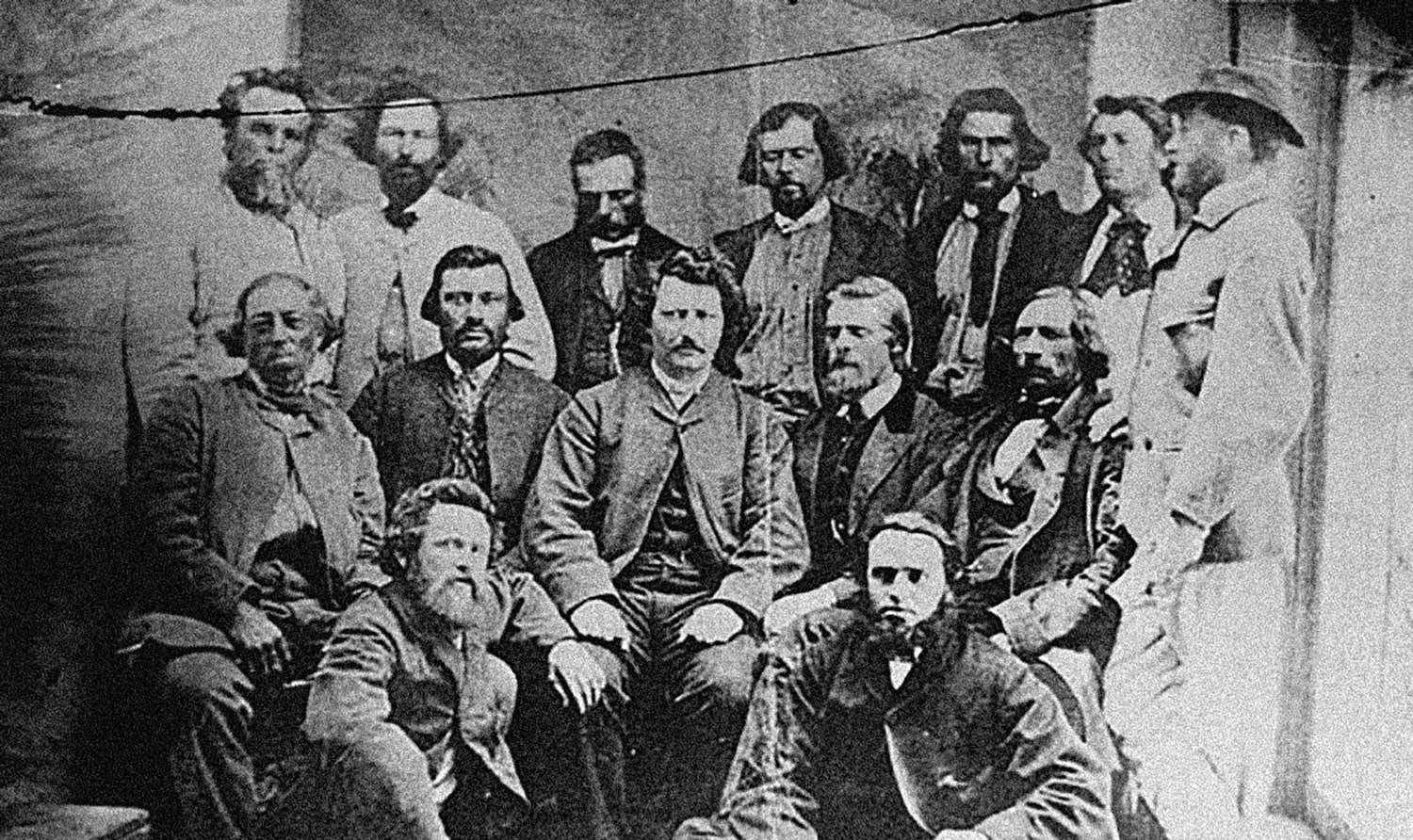 Rows of men from the provisional Metis government posing for a group photo. Louis Riel is in the centre.