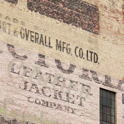 Close-up photo of ghost signs at 296 McDermot Avenue advertising Victoria Leather