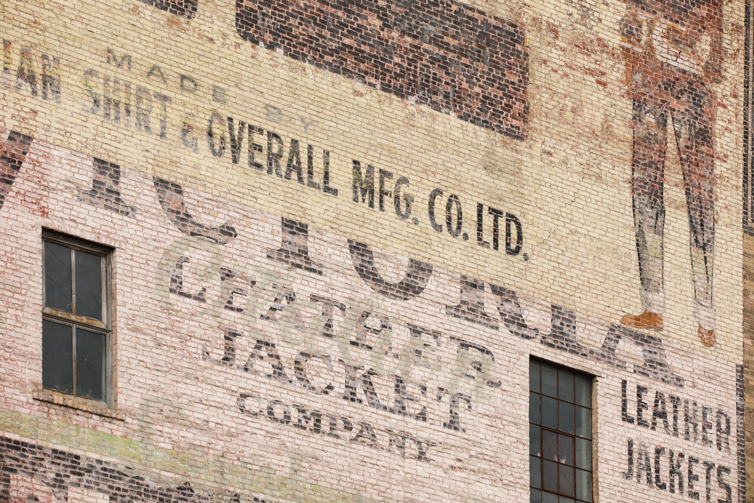 Close-up photo of ghost signs at 296 McDermot Avenue advertising Victoria Leather