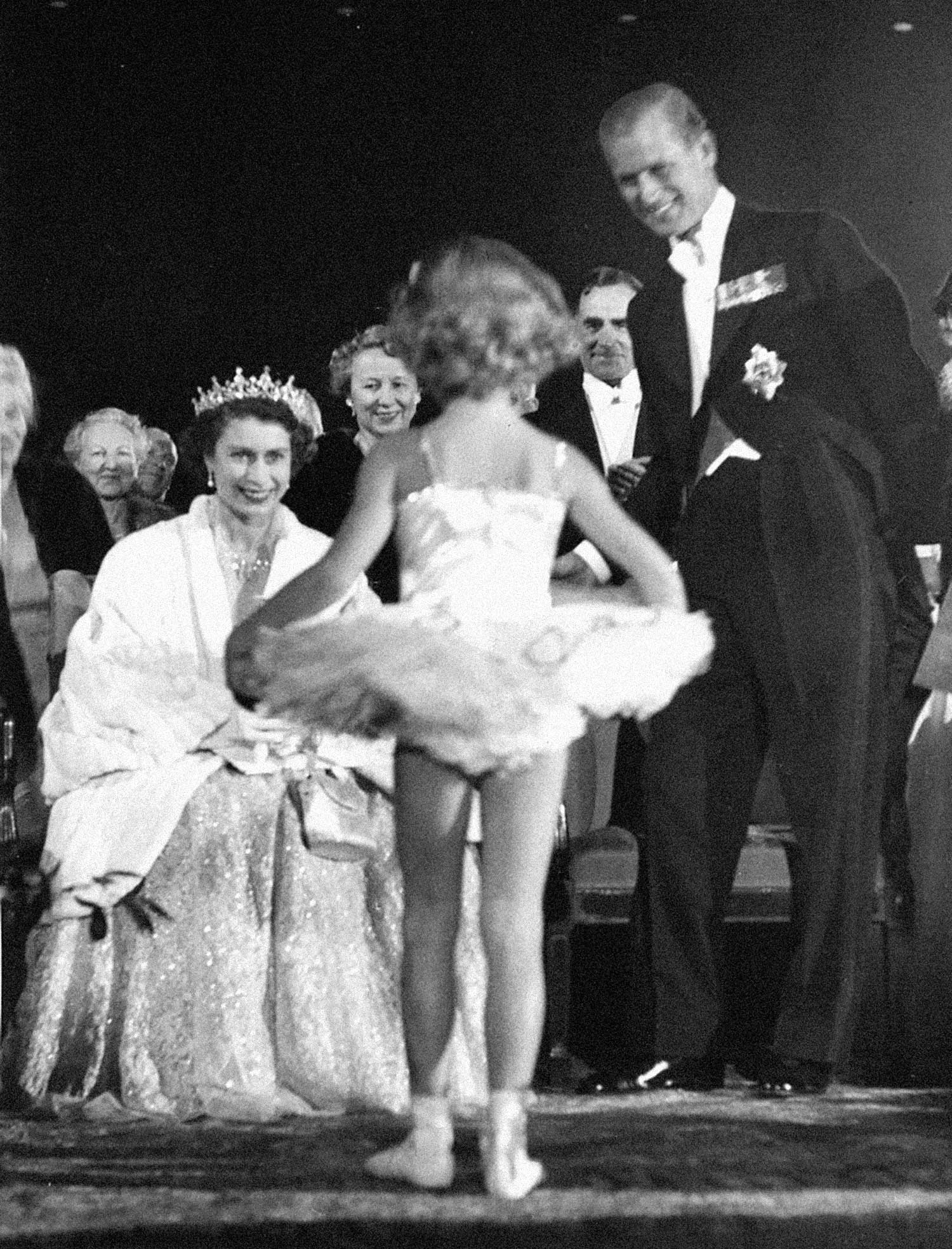 Queen Elizabeth II watching a ballerina.