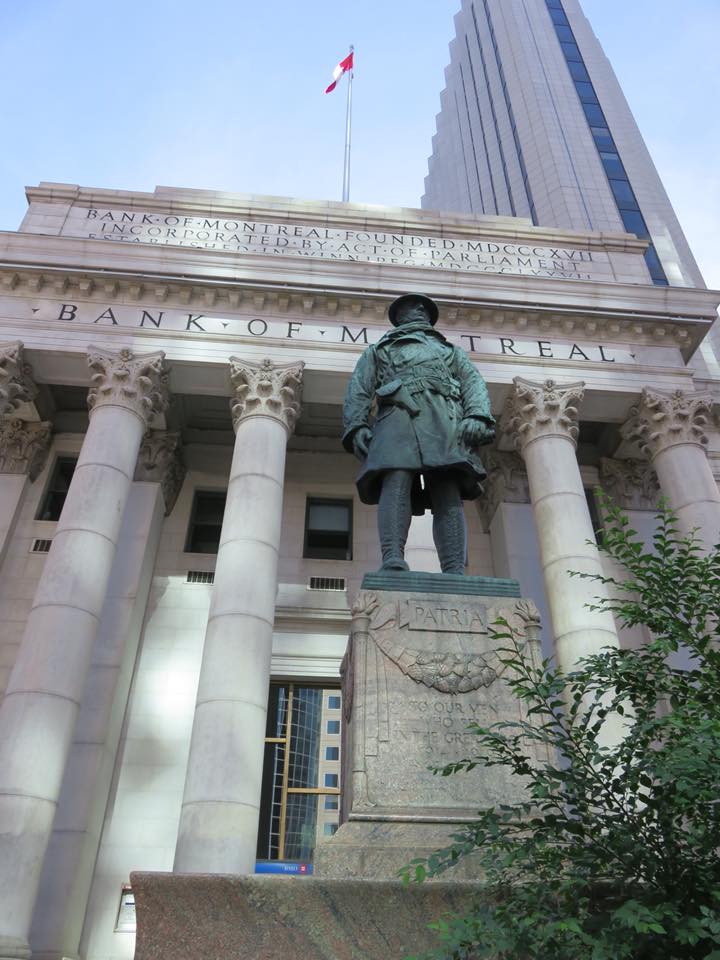 Image of a statue with the old Bank of Montreal building in the background.