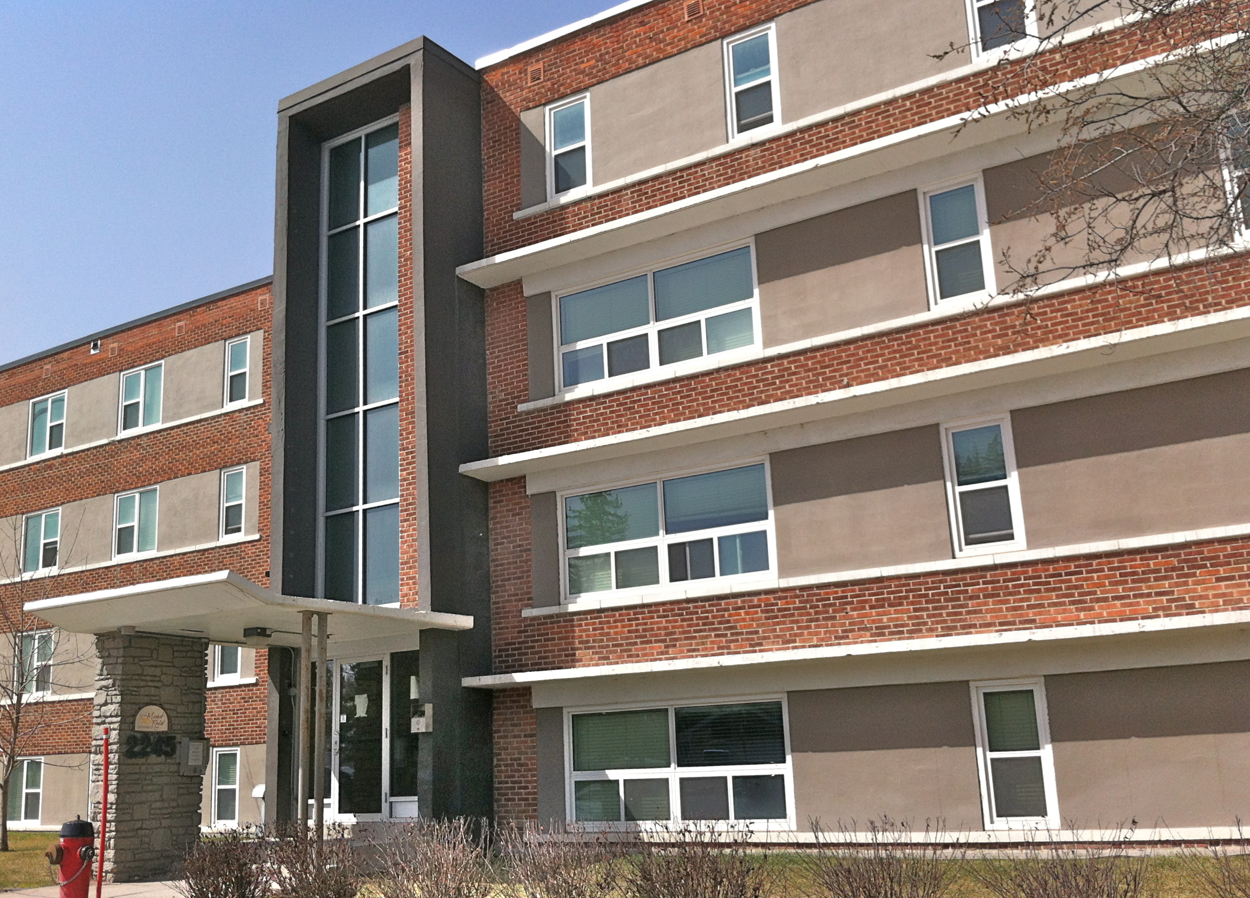 Image shows the exterior of the apartments. There is a clear view of the windows and the main entrance.