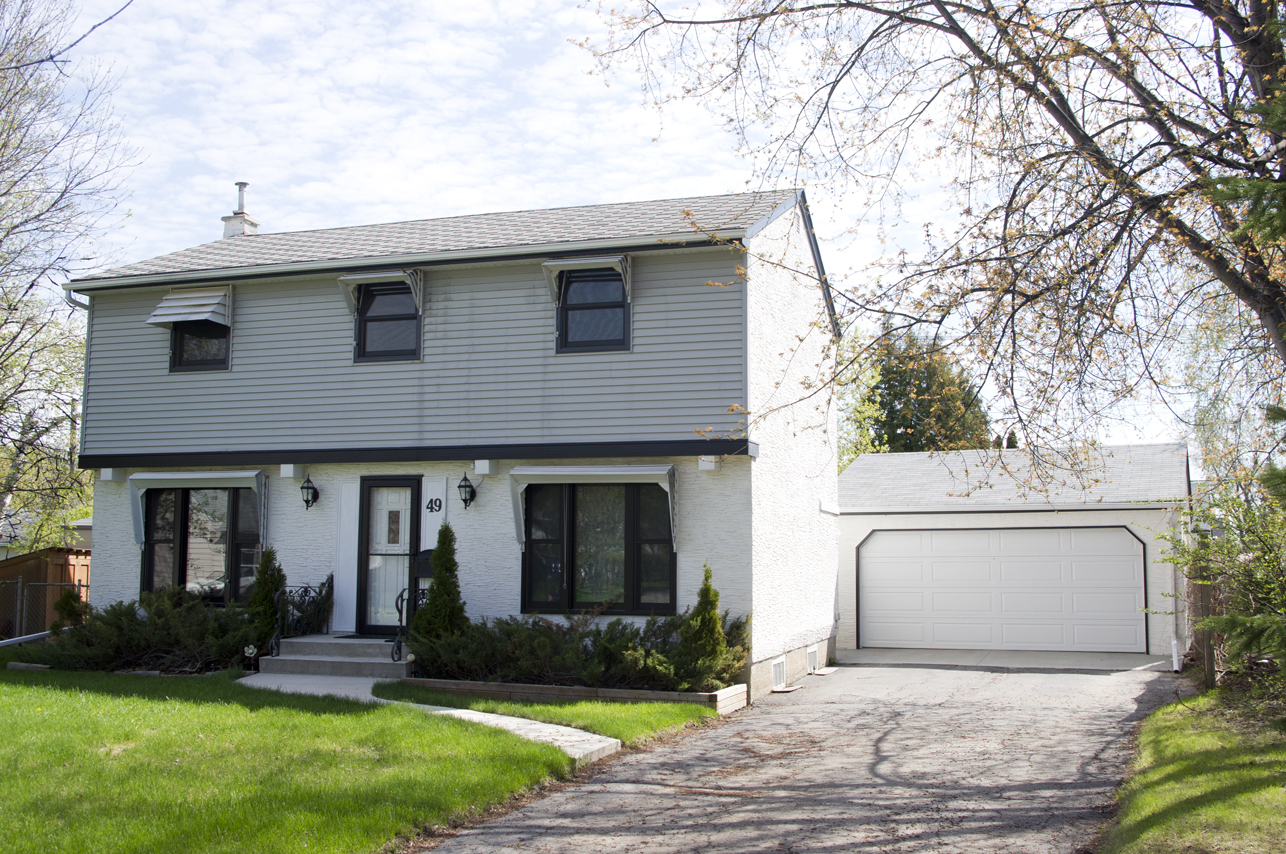 Image shows the exterior of a two-storey home, with a front-facing garage.