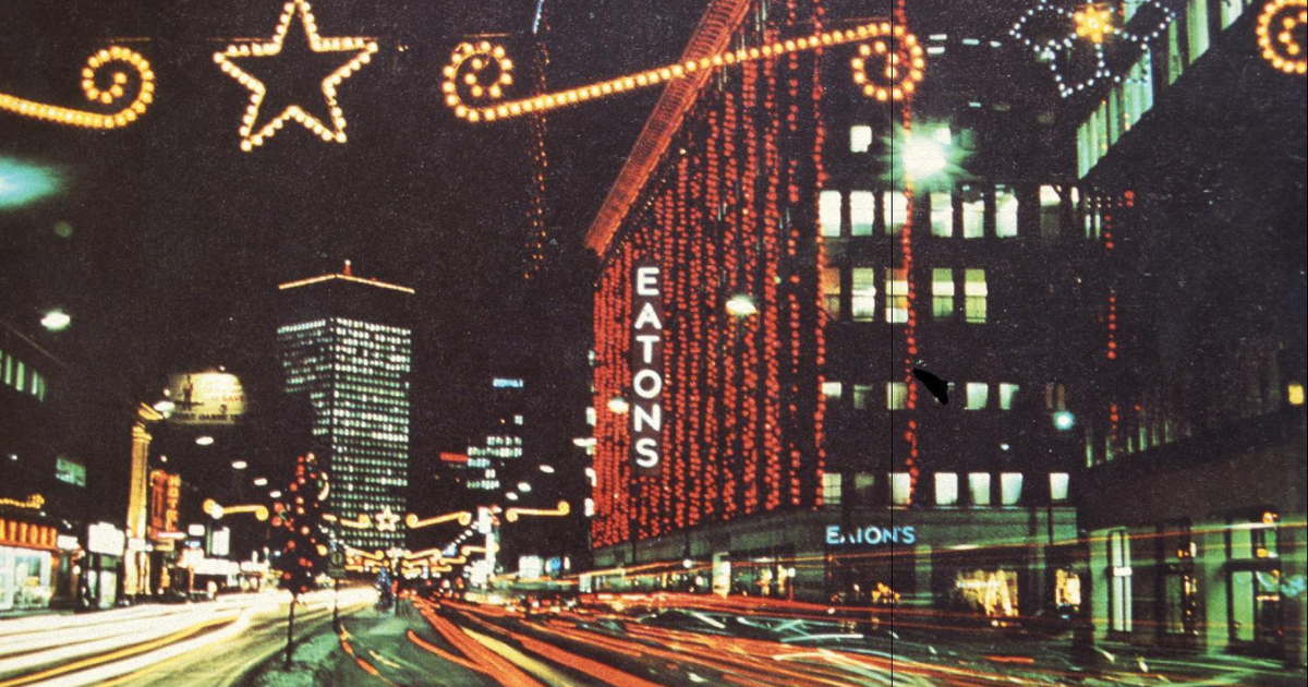 Portage Avenue decorated at Christmas looking east with Eaton's Department Store in the foreground.