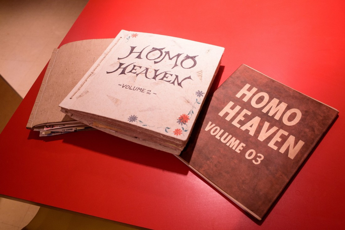 Homo Heaven guestbooks on a red table.